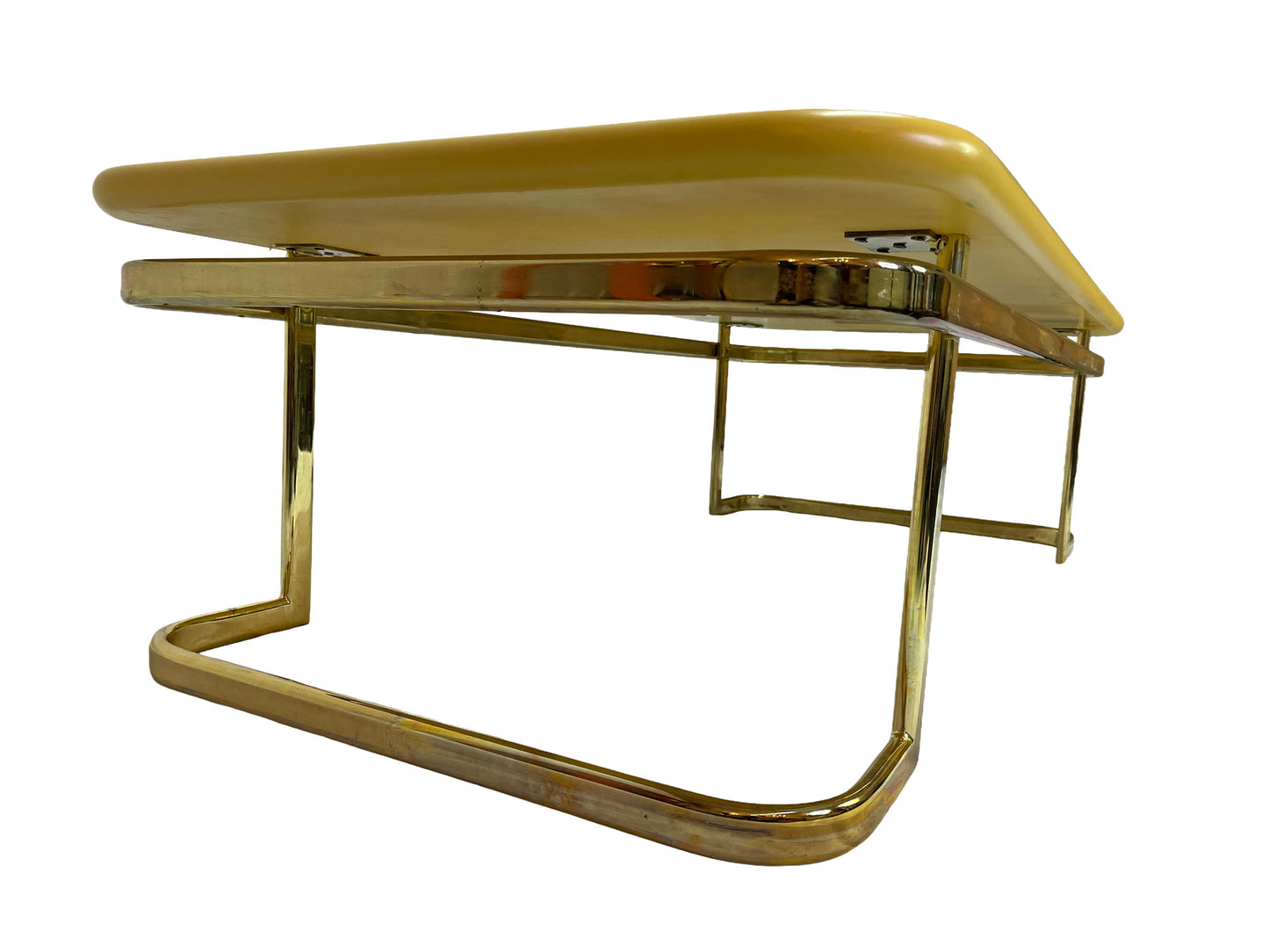 Angled detail view of 1970s Lane coffee table showing rounded yellow lacquer top and brass-tone metal frame.