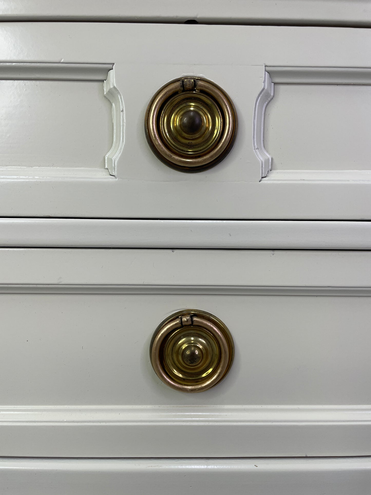 Close-up of original brass hardware on American of Martinsville nightstand with light patina drawers
