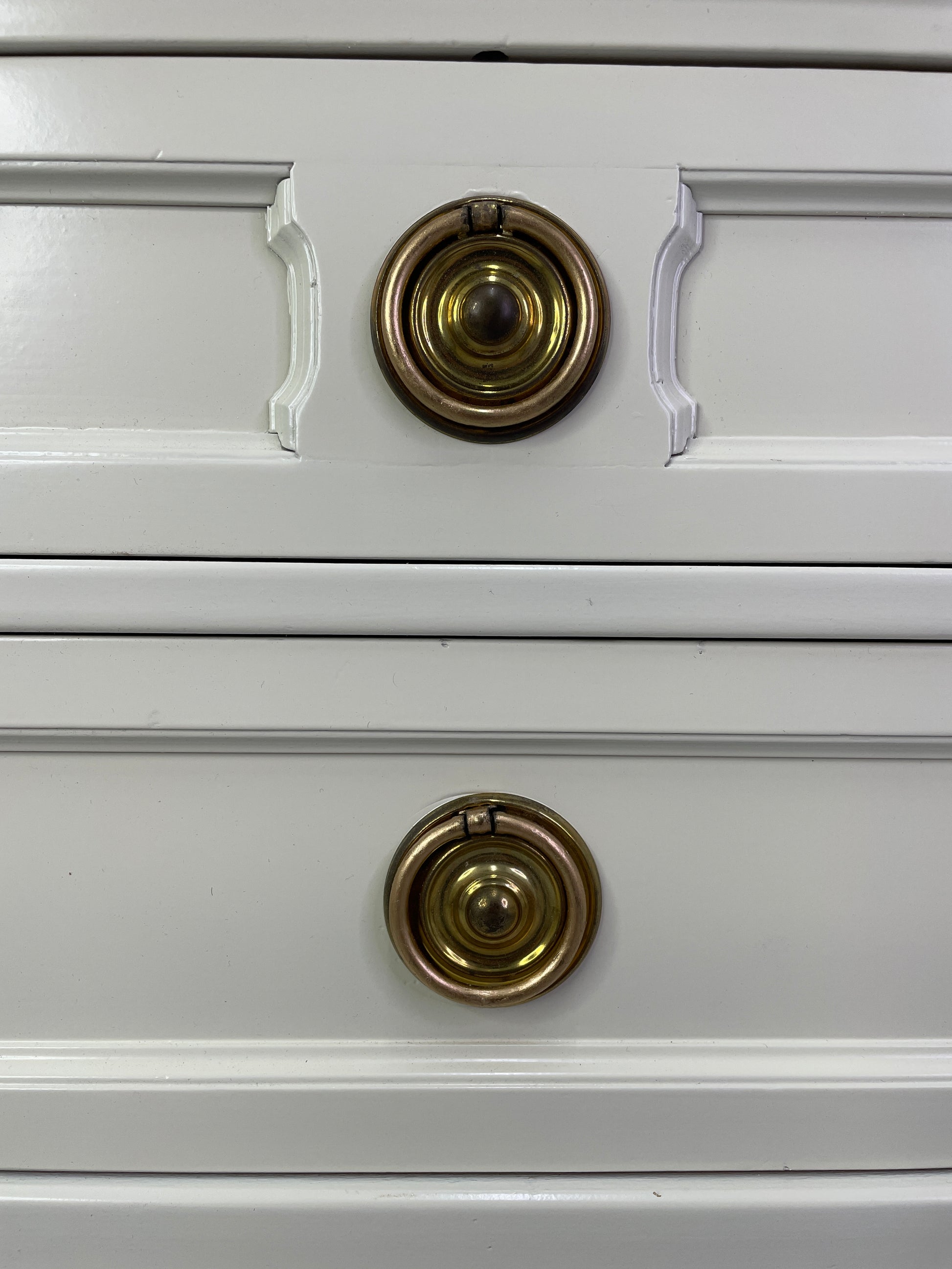 Close-up of original brass hardware on American of Martinsville nightstand with light patina drawers

