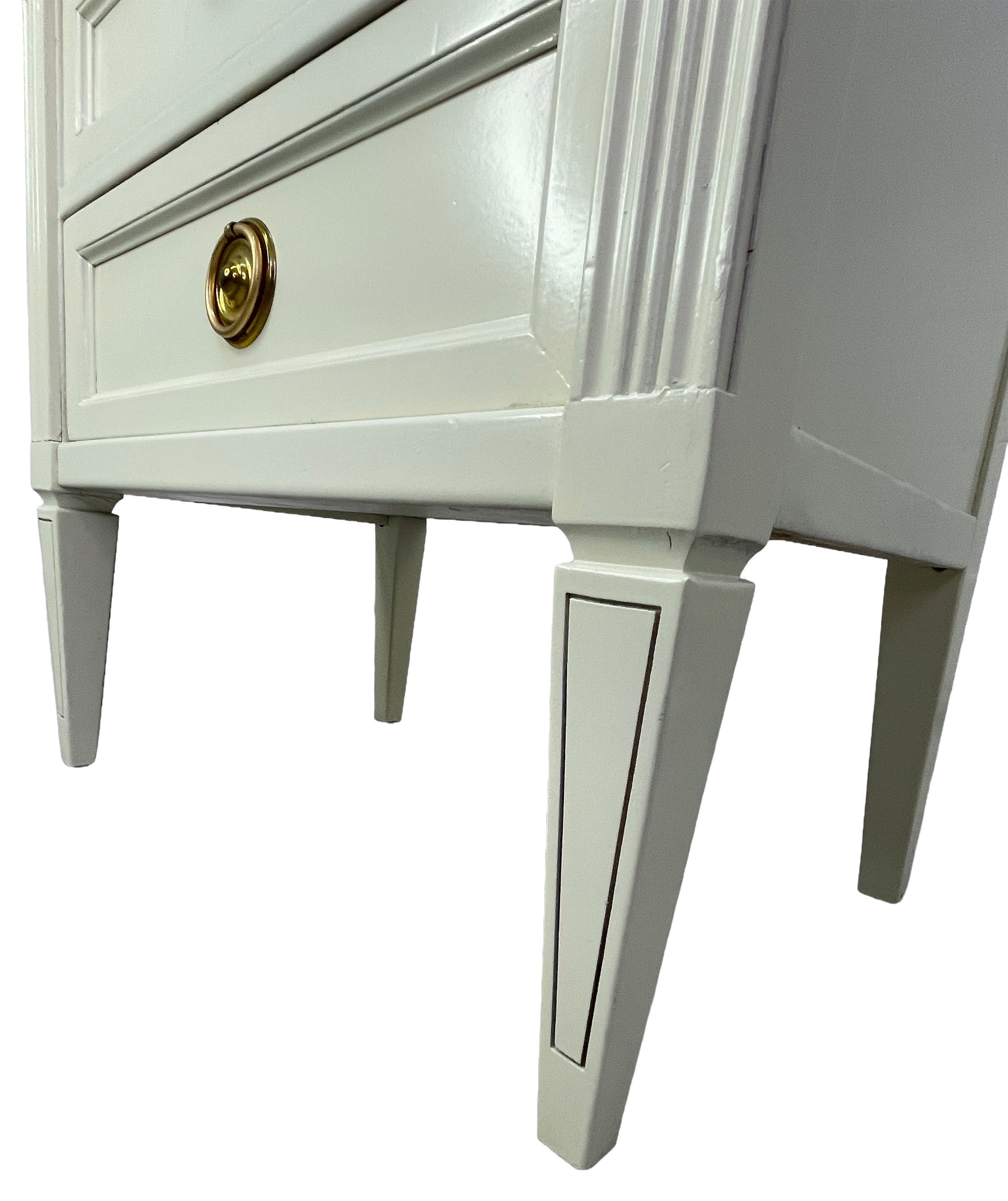 Detail of tapered legs on American of Martinsville nightstand in off-white lacquer side angle
