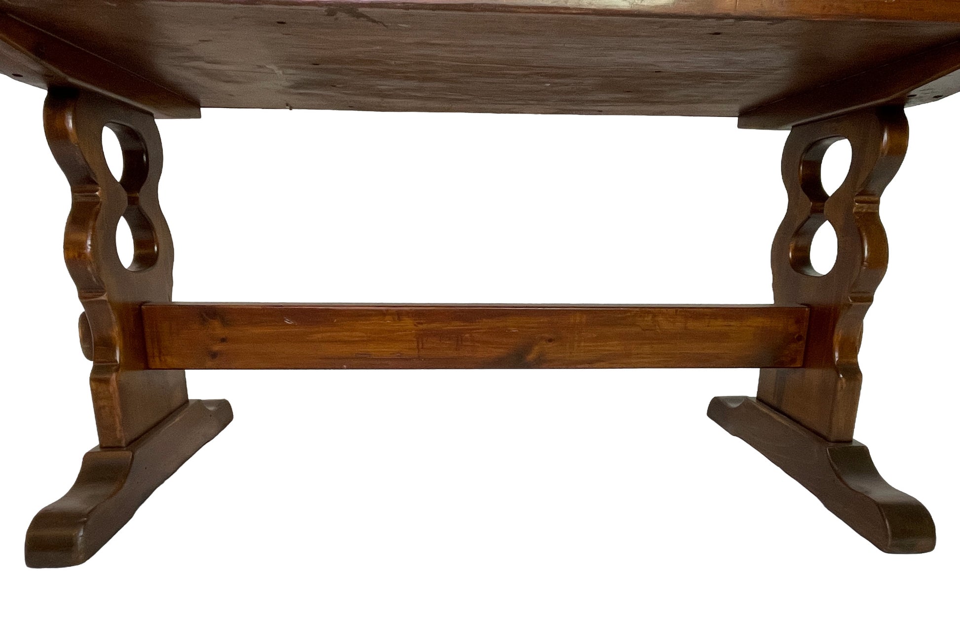 Detail of carved trestle supports and stretcher base on an early 20th century Victorian pine writing desk.