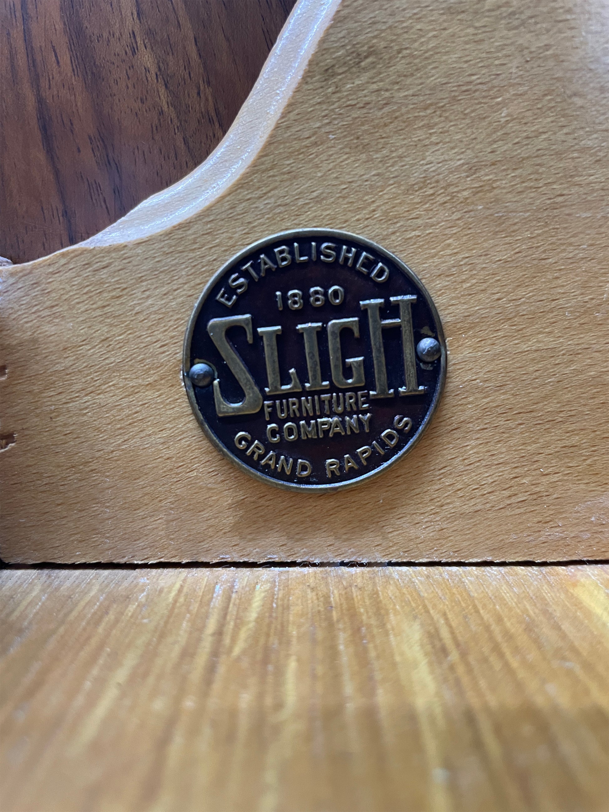 Close-up of Sligh Furniture Company maker’s mark plaque inside vintage cabinet