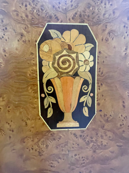 Detailed marquetry vase motif on cabinet door featuring contrasting wood inlay
