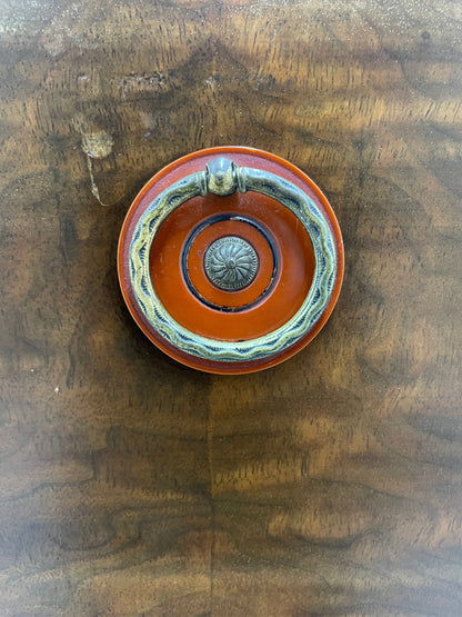 Close-up of original round drawer pull hardware with decorative metal detail on Sligh cabinet