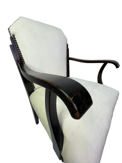 Close-up detail of curved mahogany armrest with vintage patina on an Art Deco style ivory upholstered dining armchair.