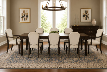 Luxury dining room featuring an Art Deco style dark mahogany dining table with six shield-back side chairs and two curved armchairs upholstered in ivory fabric with nailhead trim.