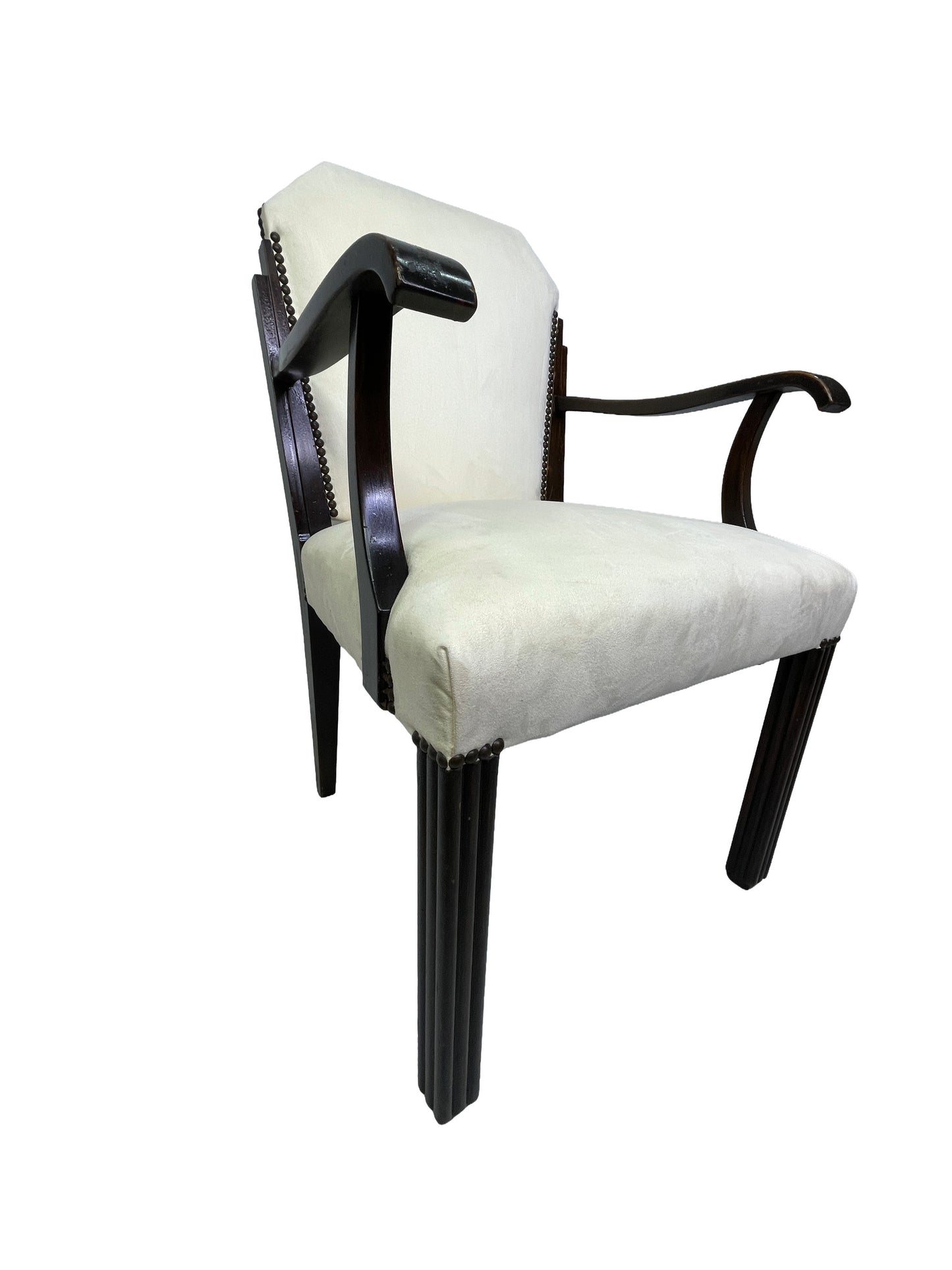 Three-quarter view of a vintage Art Deco style dining armchair with ivory upholstery, curved wooden arms, nailhead trim, and dark mahogany legs.
