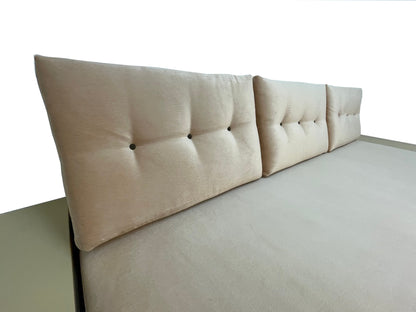 Close-up of blush pink velvet upholstery and tufted back cushions on a custom convertible daybed sofa.