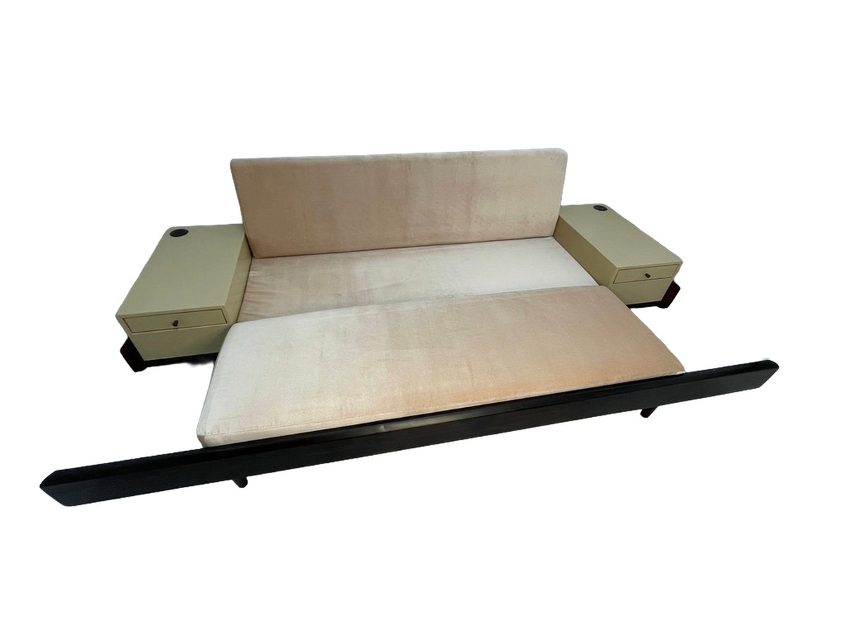 Custom convertible sofa bed shown fully extended into sleeper position with integrated side tables and blush upholstery.