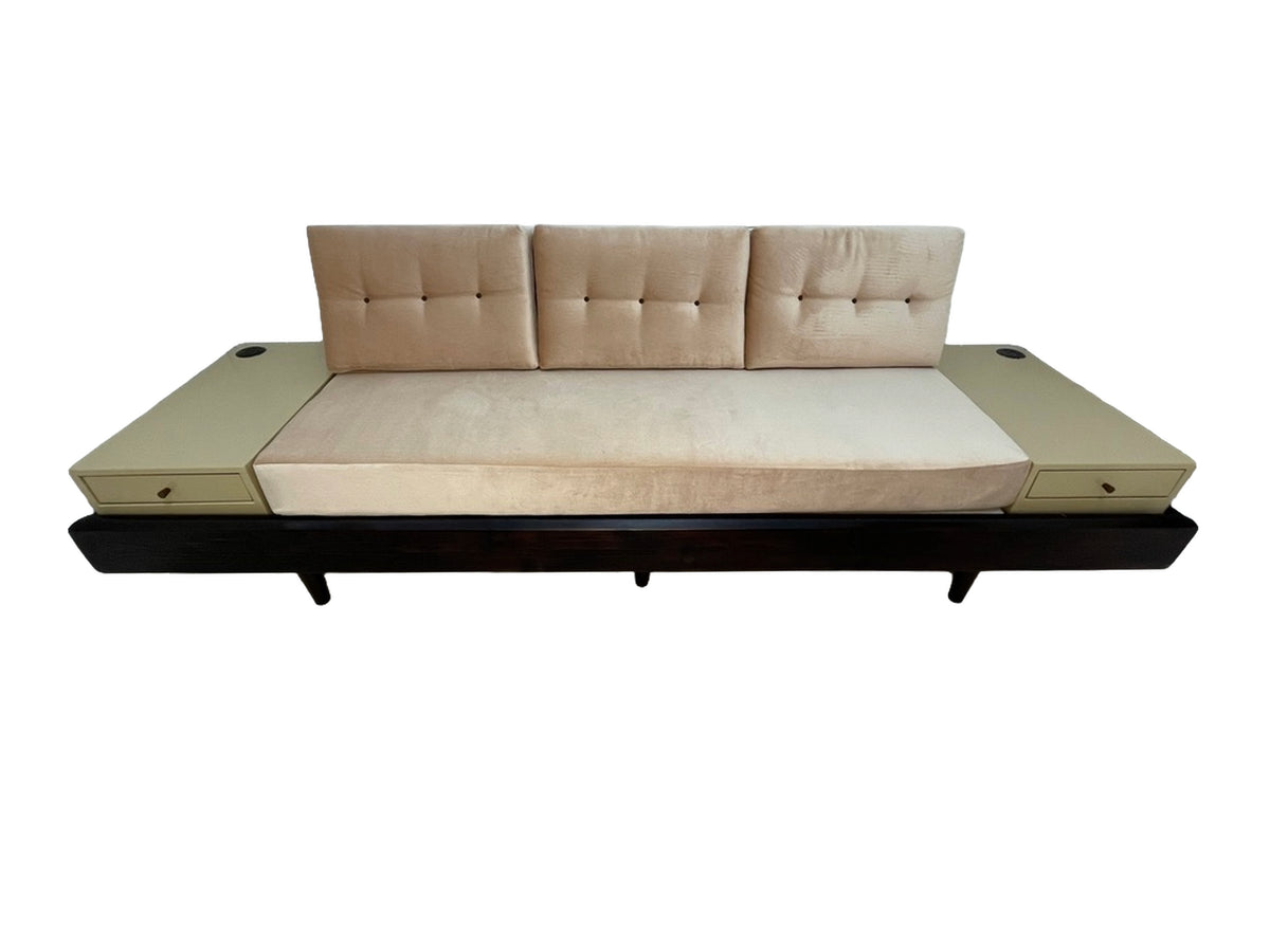 Custom convertible daybed sofa with integrated side tables, blush pink upholstery, built-in drawers, and dark wood base, circa 1990s.