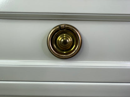 Close-up of brass hardware on American of Martinsville dresser with off-white lacquer round
