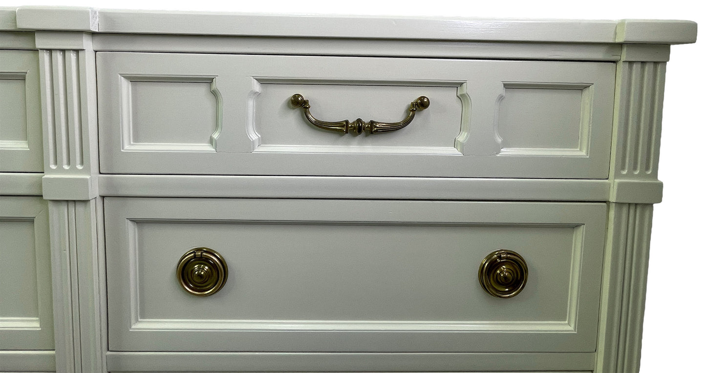Close-up of brass hardware on American of Martinsville dresser with off-white lacquer top right drawer
