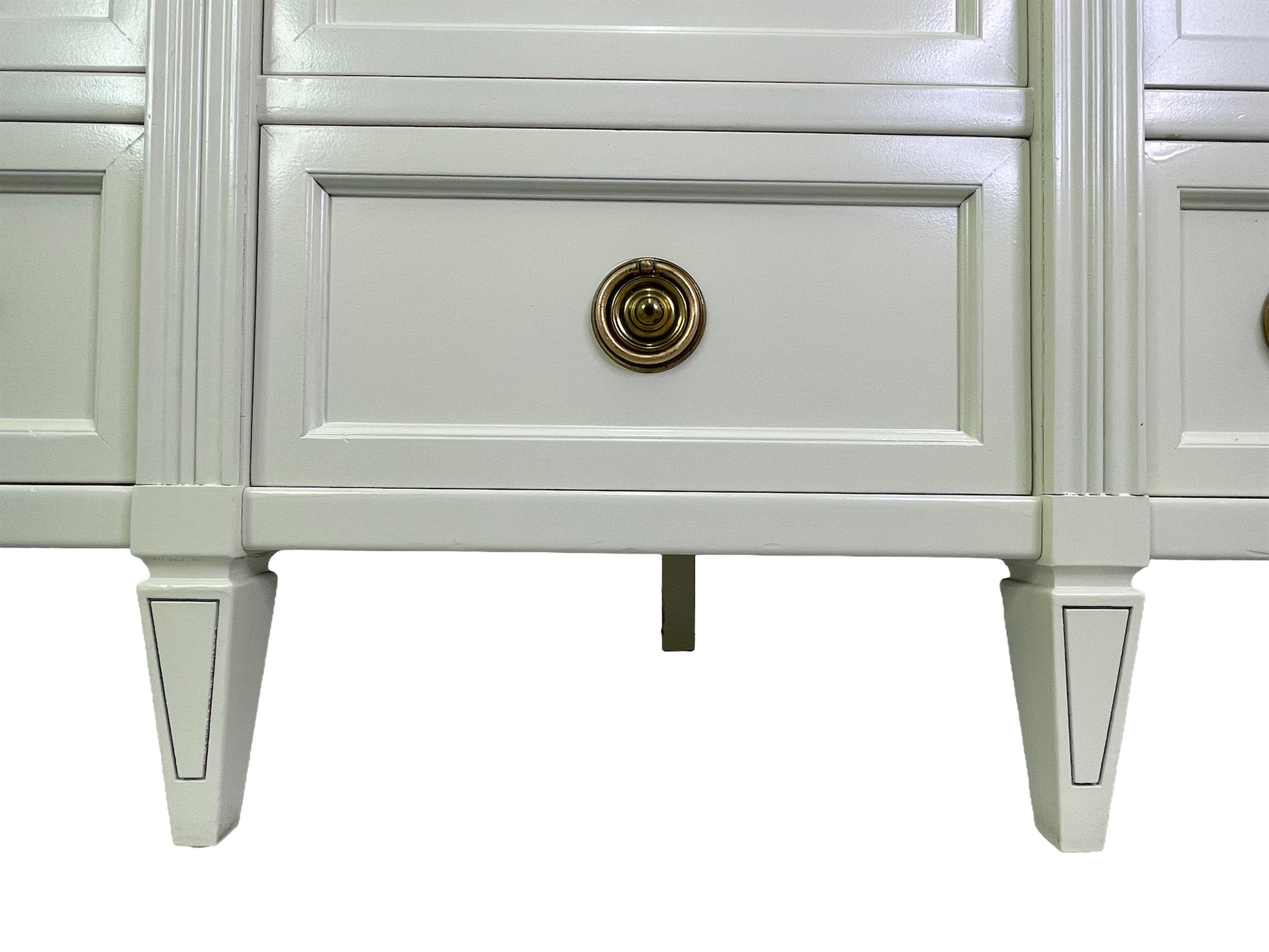 Detail of base and legs on American of Martinsville dresser in off-white lacquer
