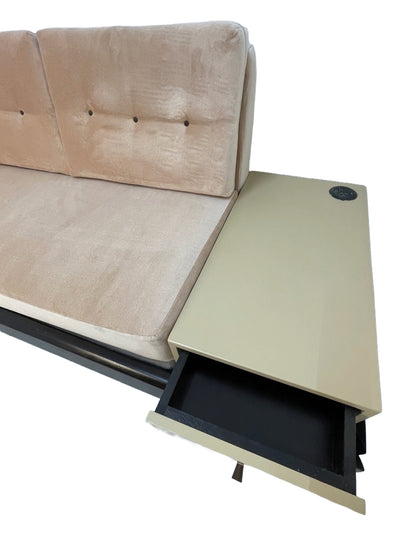 Integrated side table with storage drawer and built-in power outlet on a custom convertible sofa.