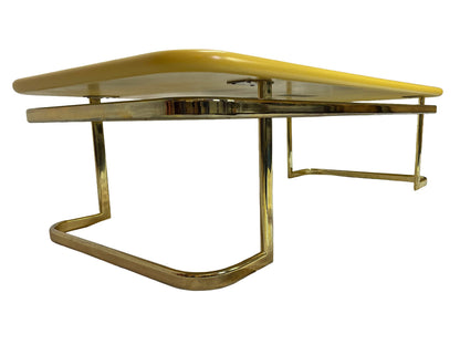 Low side profile of 1970s Lane coffee table featuring rounded yellow lacquer top and brass-tone frame.