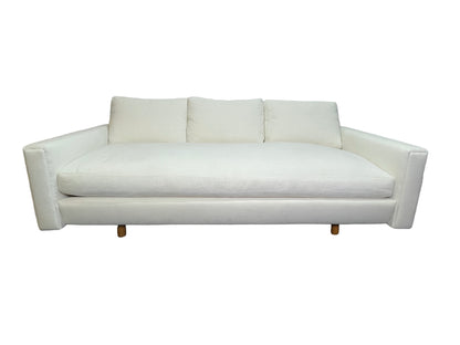Luxury contemporary white upholstered lounge daybed with deep seating and custom sculptural silhouette.