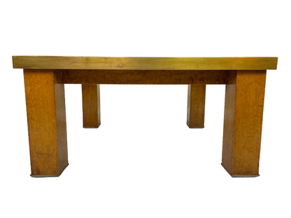 Side profile of a mid-century modern burl wood coffee table with brass trim and architectural legs.