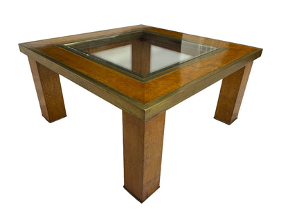 Angled view of a mid-century olive ash burl coffee table with brass trim and recessed glass insert.