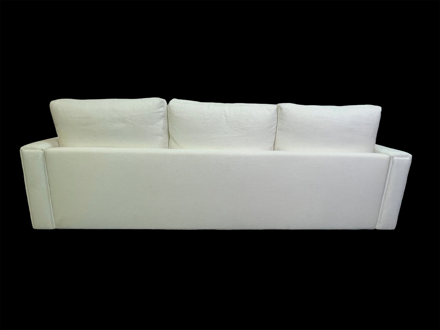 Full rear view of minimalist white upholstered daybed with oversized back cushions and clean architectural lines.