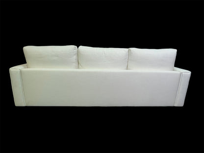 Full rear view of minimalist white upholstered daybed with oversized back cushions and clean architectural lines.