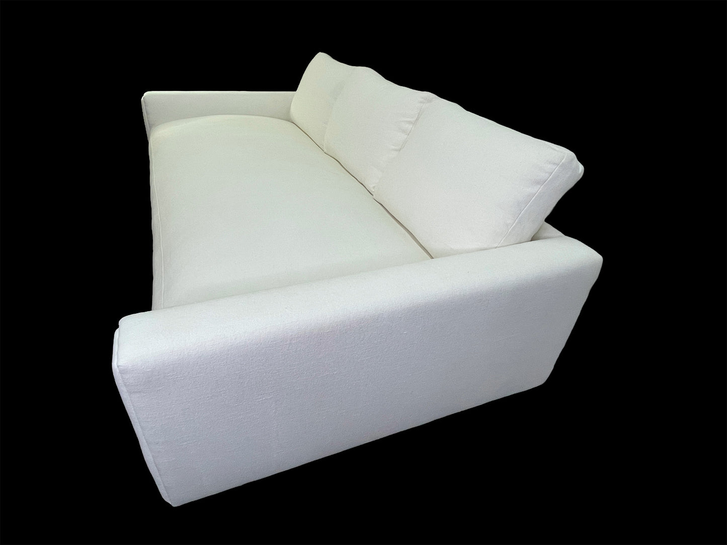 Rear angled view of custom white upholstered daybed with oversized back cushions and minimalist silhouette.