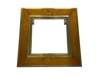 Top view of an olive ash burl coffee table featuring brass framing and a recessed glass center panel.