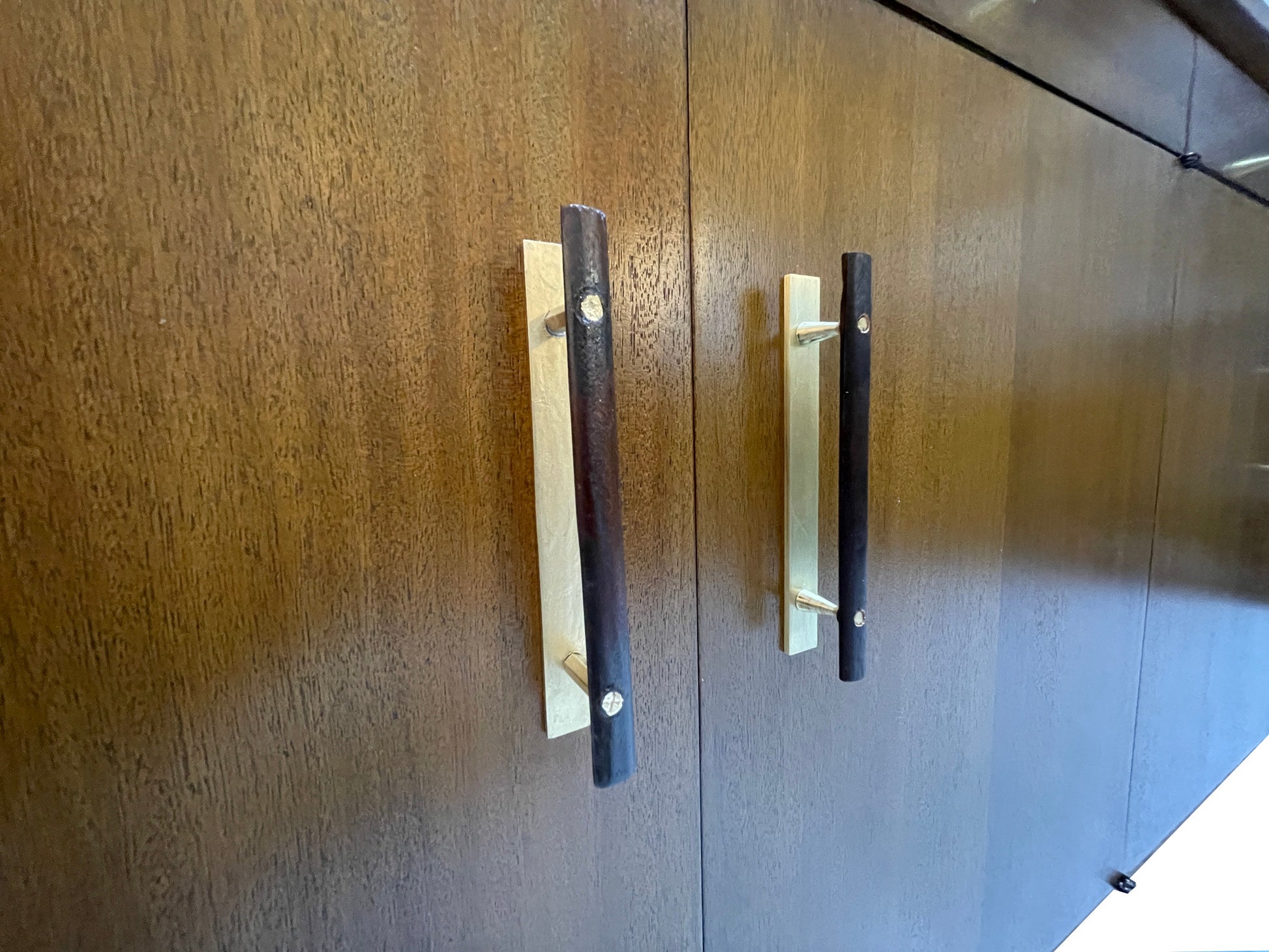 Close-up of original brass and wood cabinet pulls on a restored Paul McCobb for Calvin Group ribbon mahogany credenza, circa 1960s.