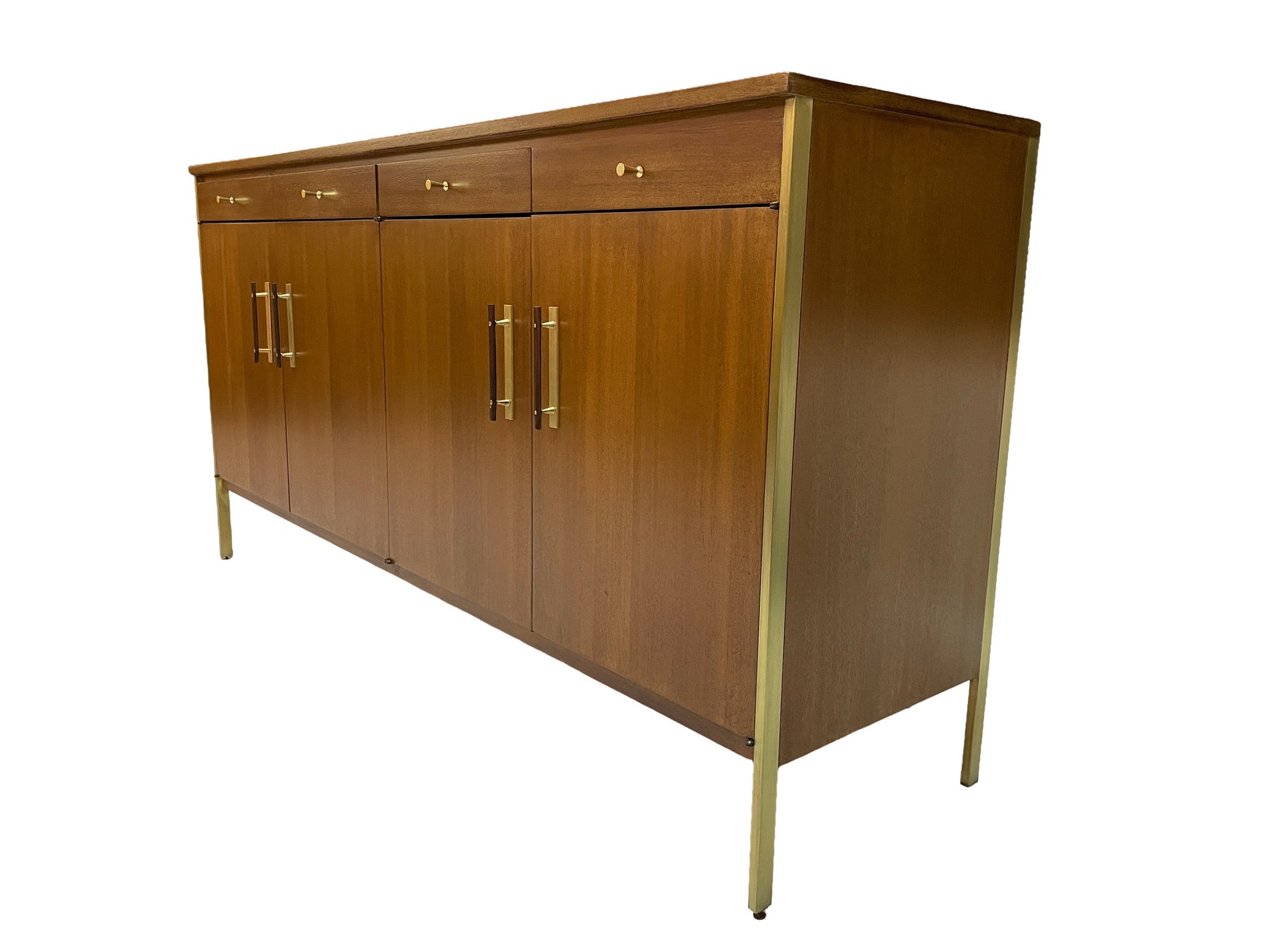 Right-angle view of a restored Paul McCobb credenza for Calvin Group showcasing ribbon mahogany wood grain, brass hardware, and four-door storage cabinet design.