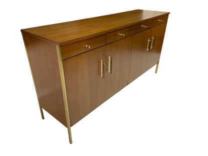 Three-quarter top view of a Paul McCobb for Calvin Group ribbon mahogany credenza featuring brass hardware, brass legs, and a restored walnut-toned finish, circa 1960s.