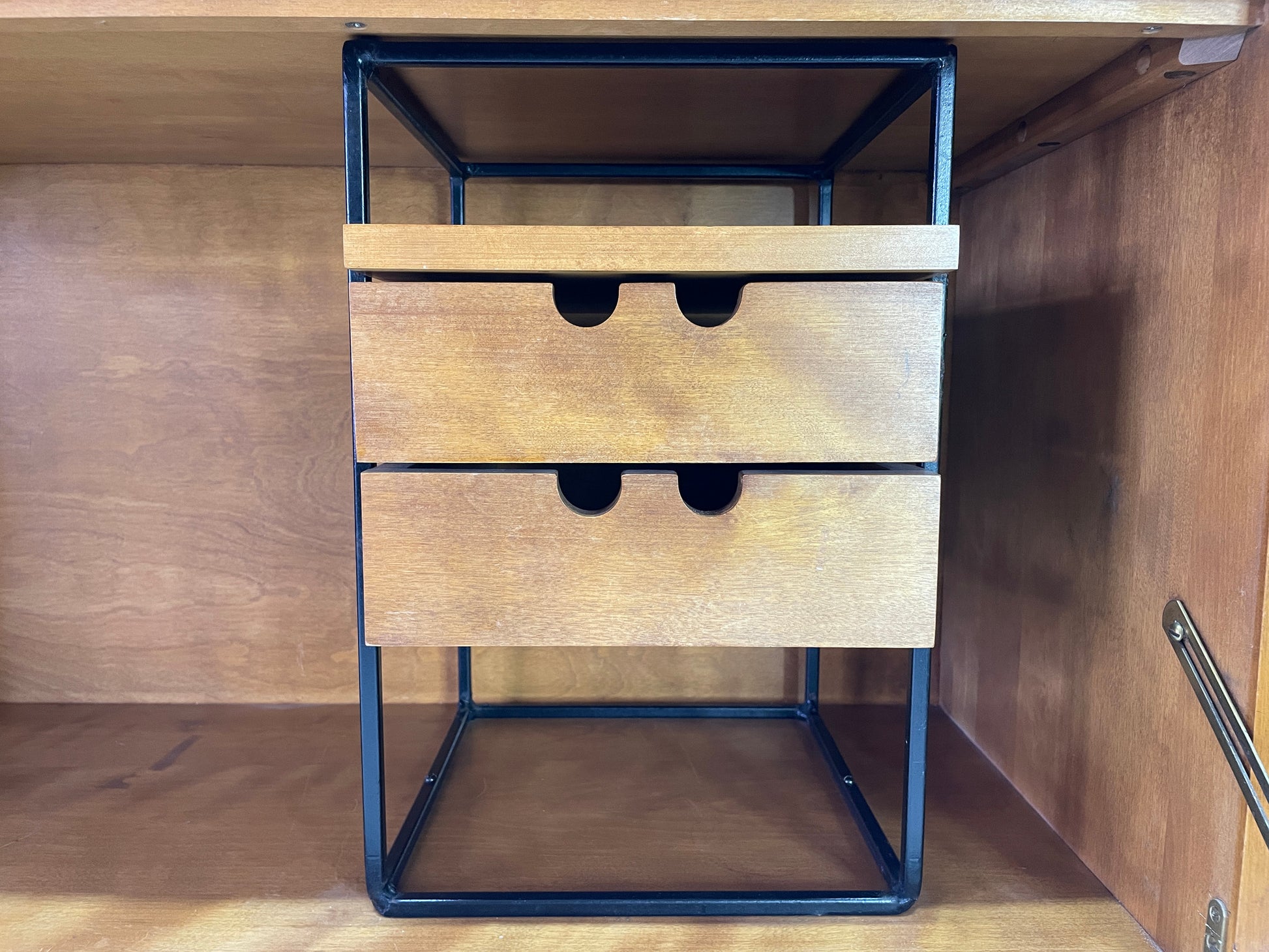 Interior drawer organizer detail inside Paul McCobb Planner Group secretary desk featuring black metal frame and maple storage drawers.