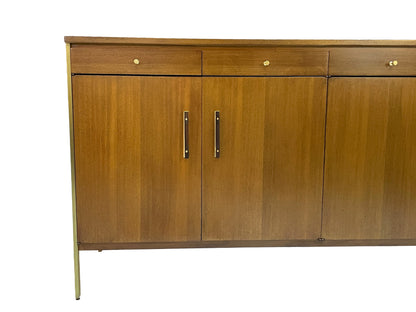 Close-up detail of brass and wood cabinet pulls on a restored Paul McCobb Calvin Group ribbon mahogany credenza, circa 1965.