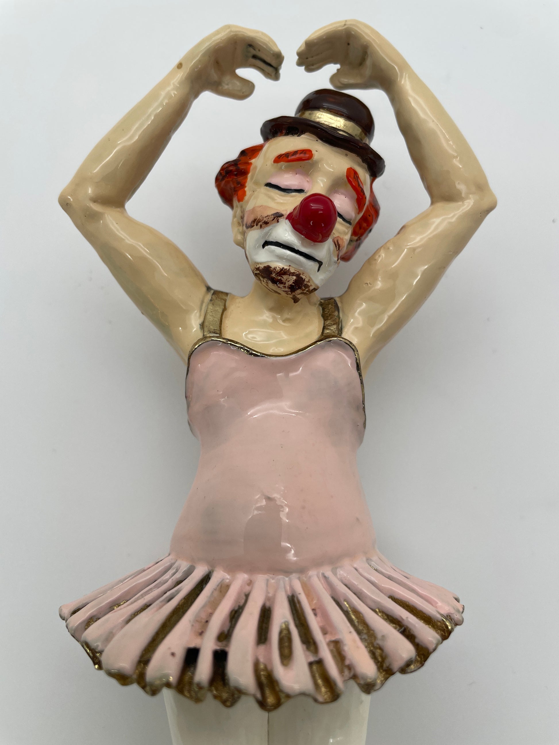 Close-up of the expressive face and upper body of a vintage Ron Lee ballerina clown sculpture with pink tutu, hand-painted finish, and gold-plated accents.