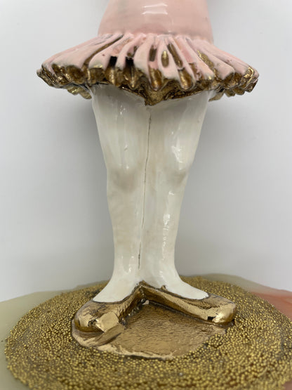 Close-up of the pink tutu, gold-plated ballet shoes, and textured stage on a vintage Ron Lee ballerina clown sculpture.
