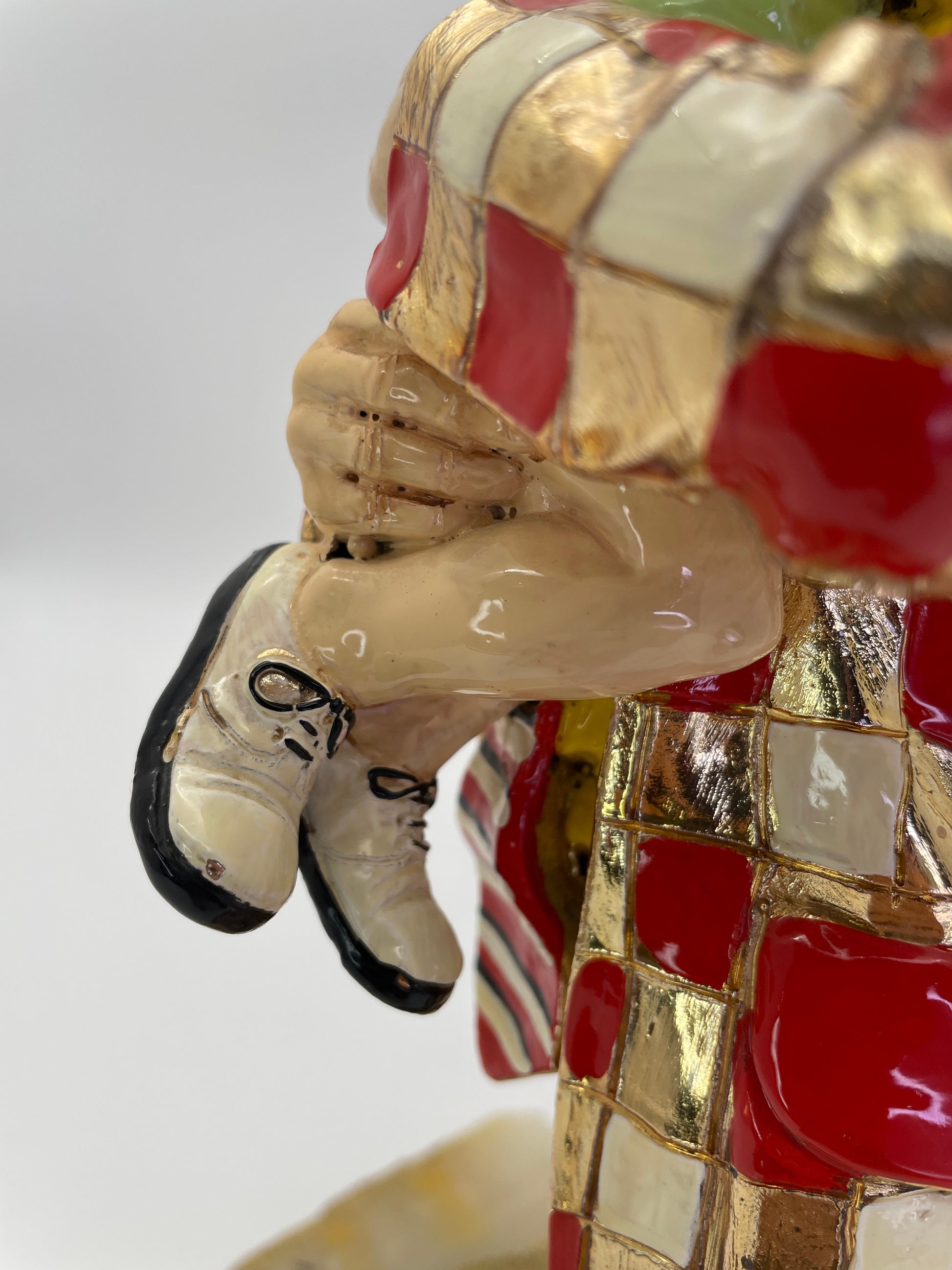 Close-up of the child’s legs and the clown’s gold-plated costume, showcasing the handcrafted detailing of a Ron Lee sculpture.