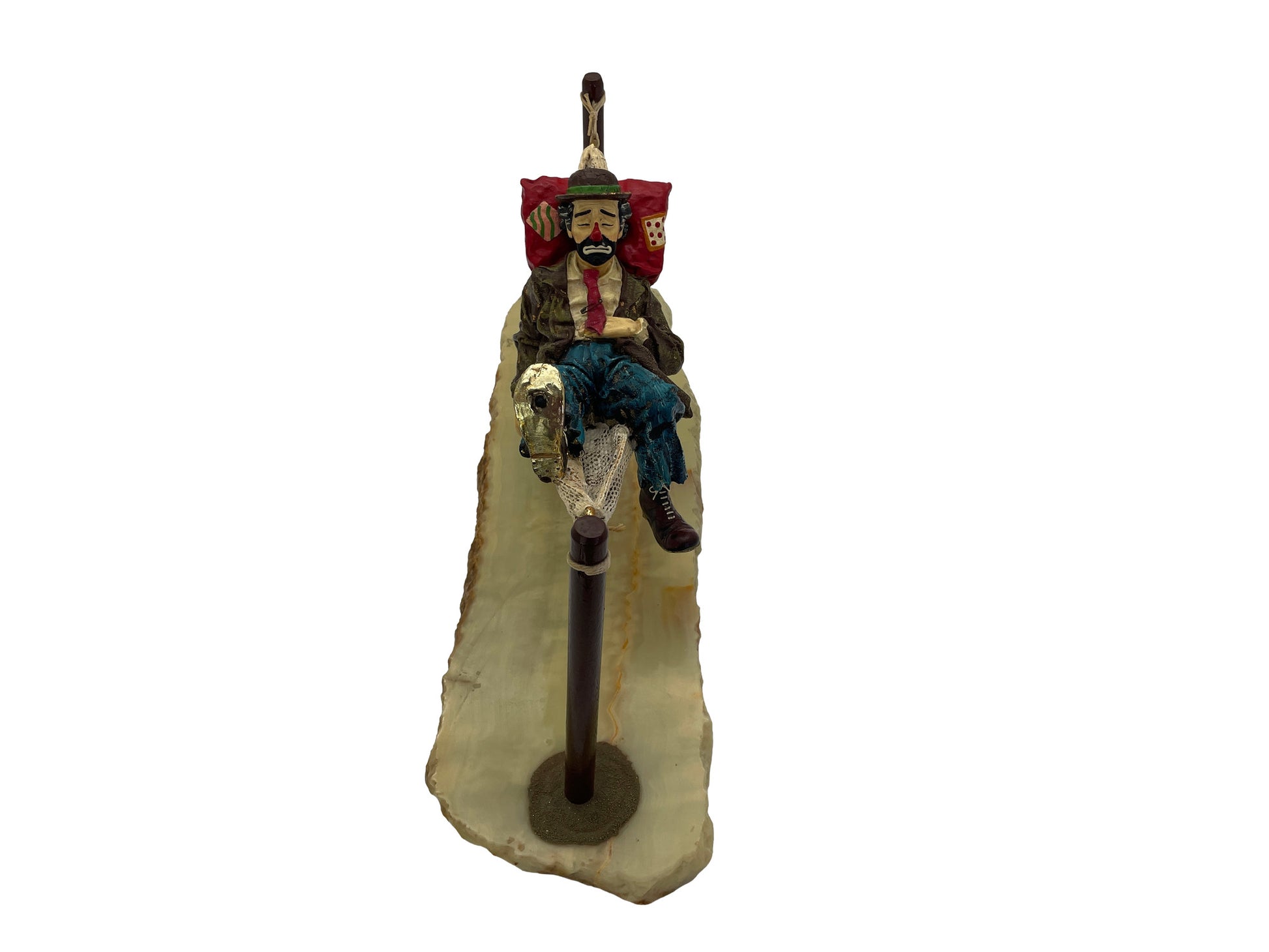 Front view of a signed 1988 Ron Lee hobo clown sculpture resting in a hammock on a polished natural onyx base.