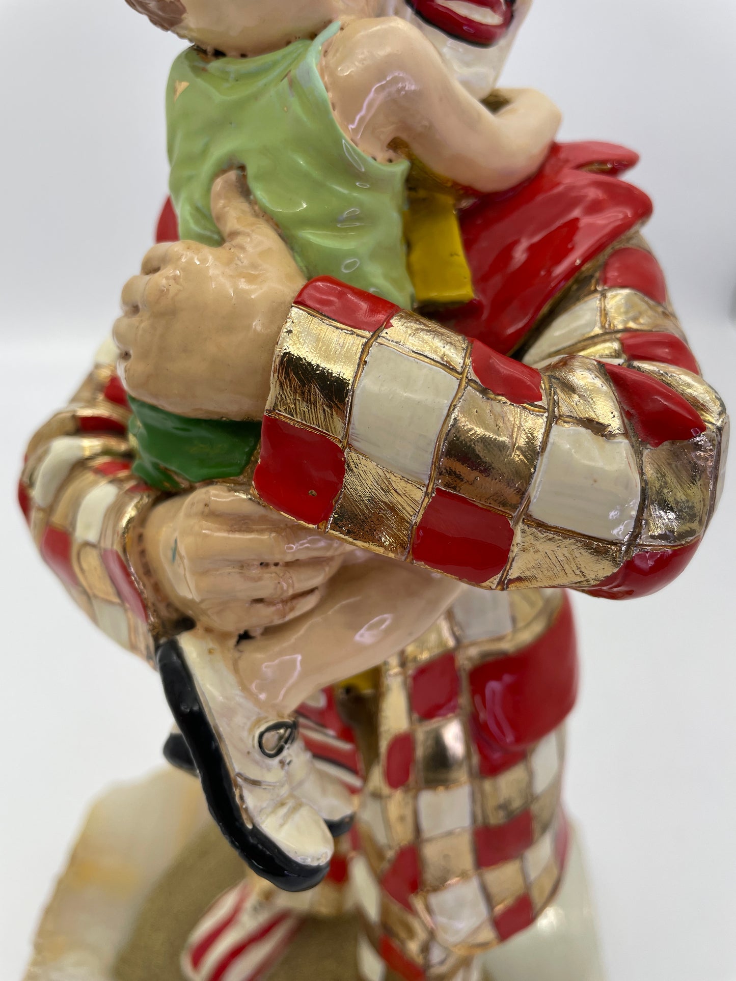 Close-up of the child’s embrace and hand-painted enamel details on a signed Ron Lee clown sculpture with 24K gold-plated accents.