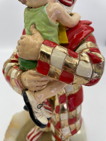 Close-up of the child’s embrace and hand-painted enamel details on a signed Ron Lee clown sculpture with 24K gold-plated accents.