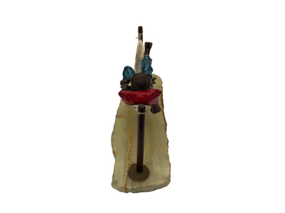 Rear view of a signed Ron Lee hobo clown sculpture featuring a hand-painted figure suspended in a hammock above a natural onyx base.