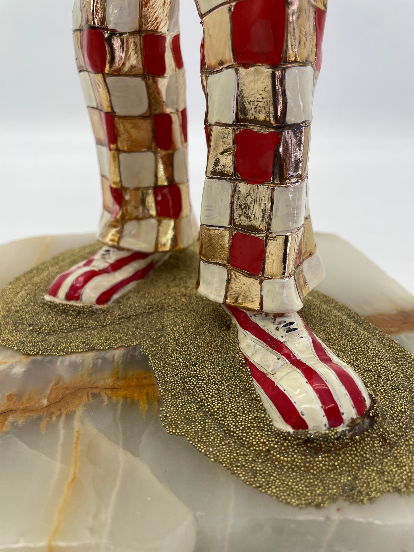 Detail of the iconic red-and-white clown shoes, textured ground, and natural onyx base on a signed Ron Lee sculpture.