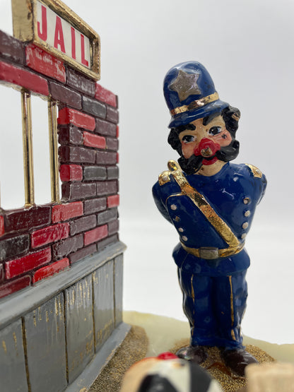 Close-up of the hand-painted police clown beside the jail wall in Ron Lee’s Great Escape sculpture with 24K gold-plated accents.