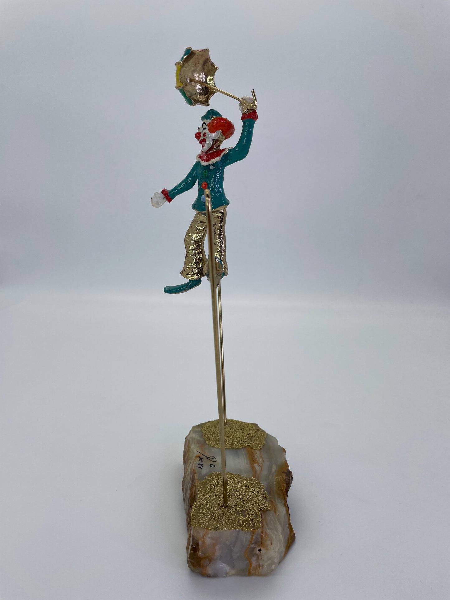 Side profile of a vintage Ron Lee circus clown sculpture on suspended wire.