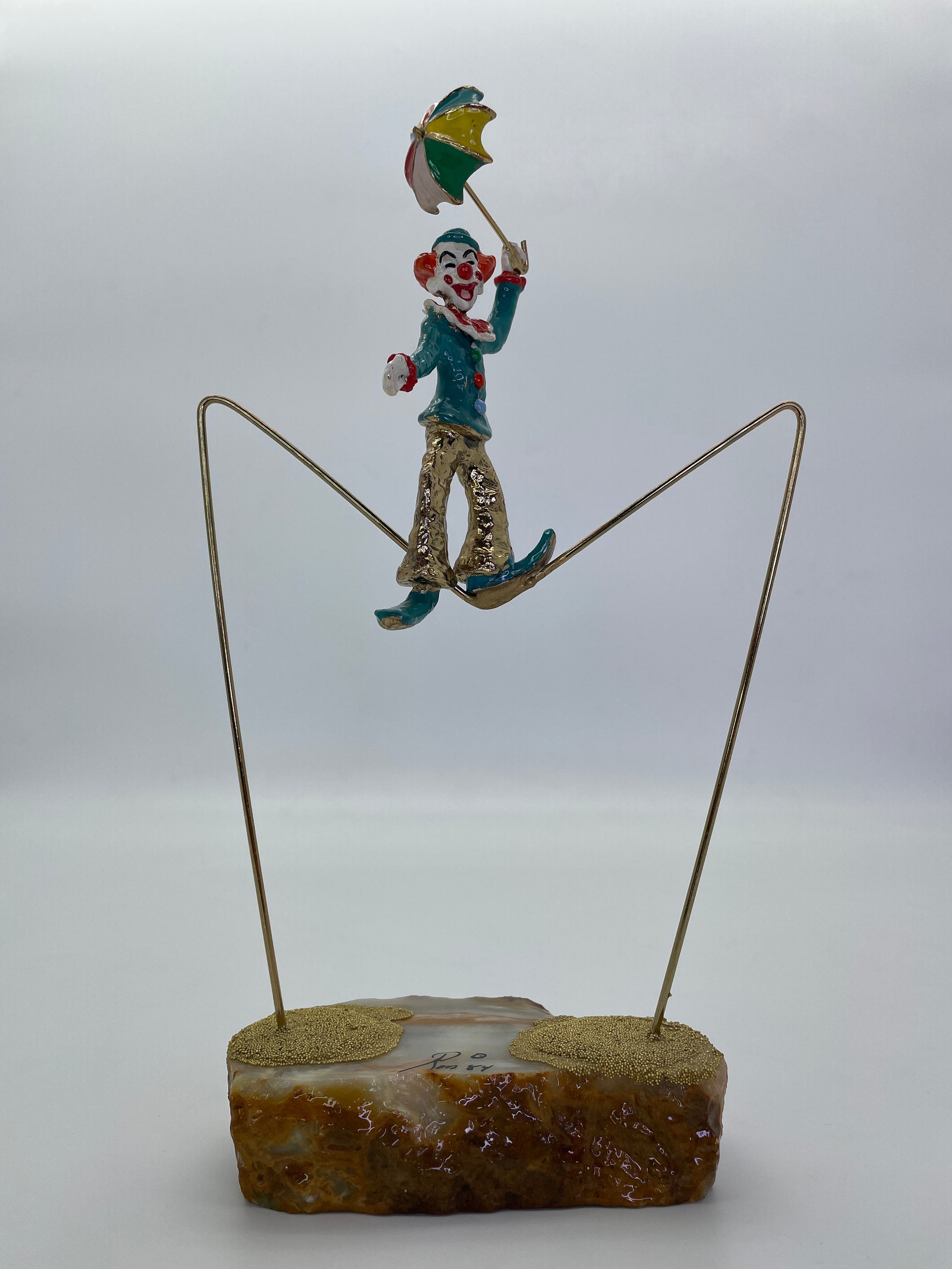Full front view of a vintage Ron Lee high wire clown sculpture with suspended brass wire.