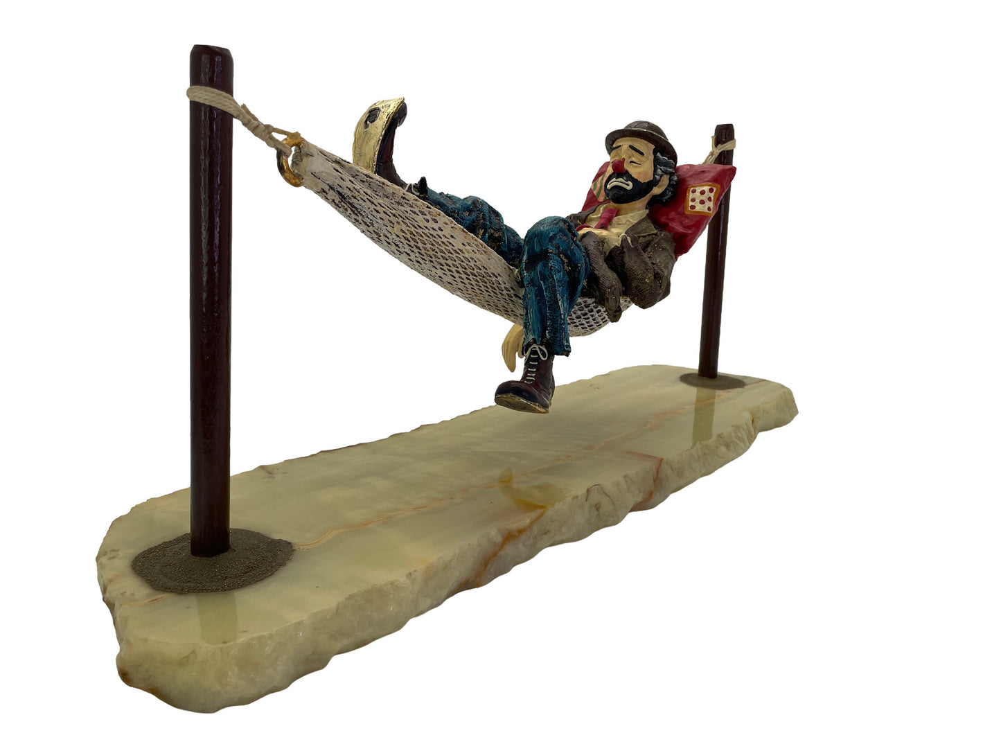 Perspective view of a signed 1988 Ron Lee hobo clown sculpture sleeping in a hammock with a natural onyx base and hand-painted details.