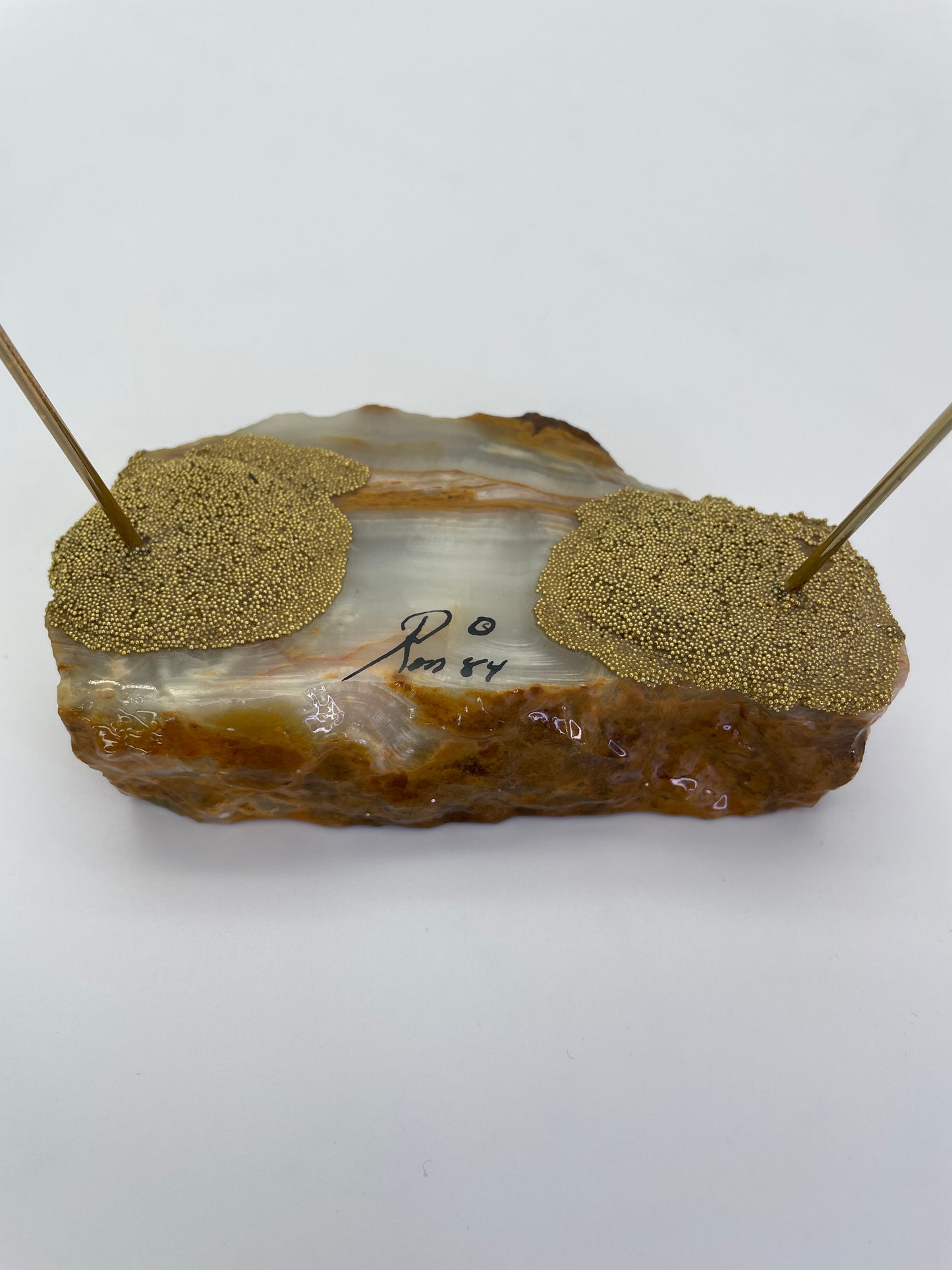 Close-up of the signed natural onyx base on a vintage Ron Lee circus clown sculpture.