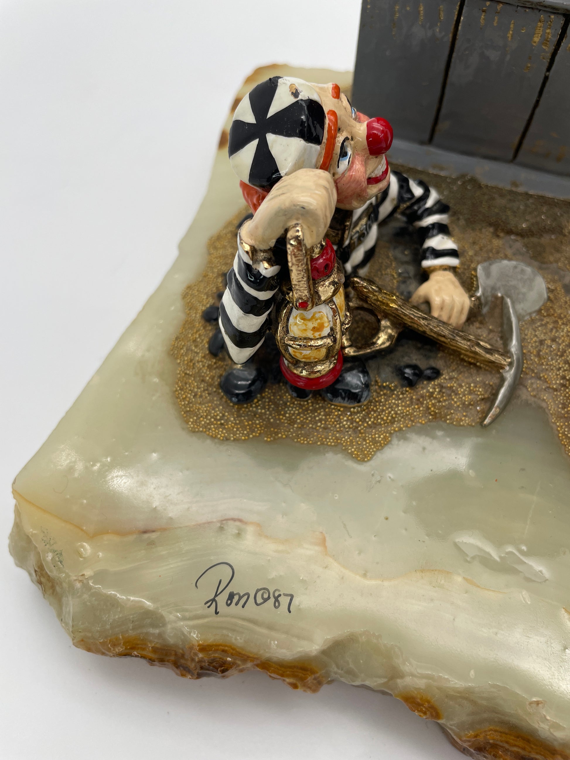 Hand-signed Ron ’87 signature on the natural onyx base of the Ron Lee Great Escape police and prisoner clown sculpture.