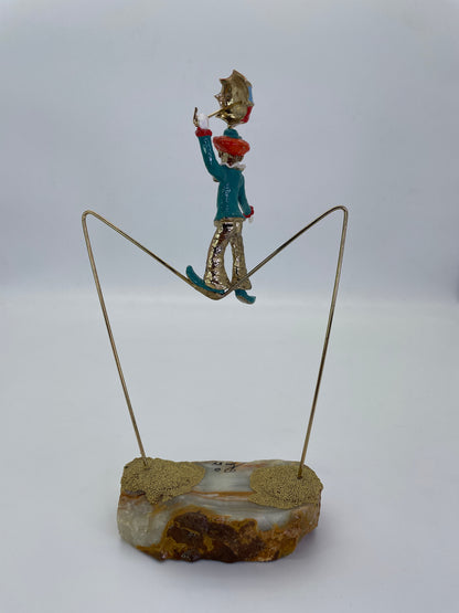 Back view of a vintage Ron Lee clown balancing on a tightrope with umbrella.
