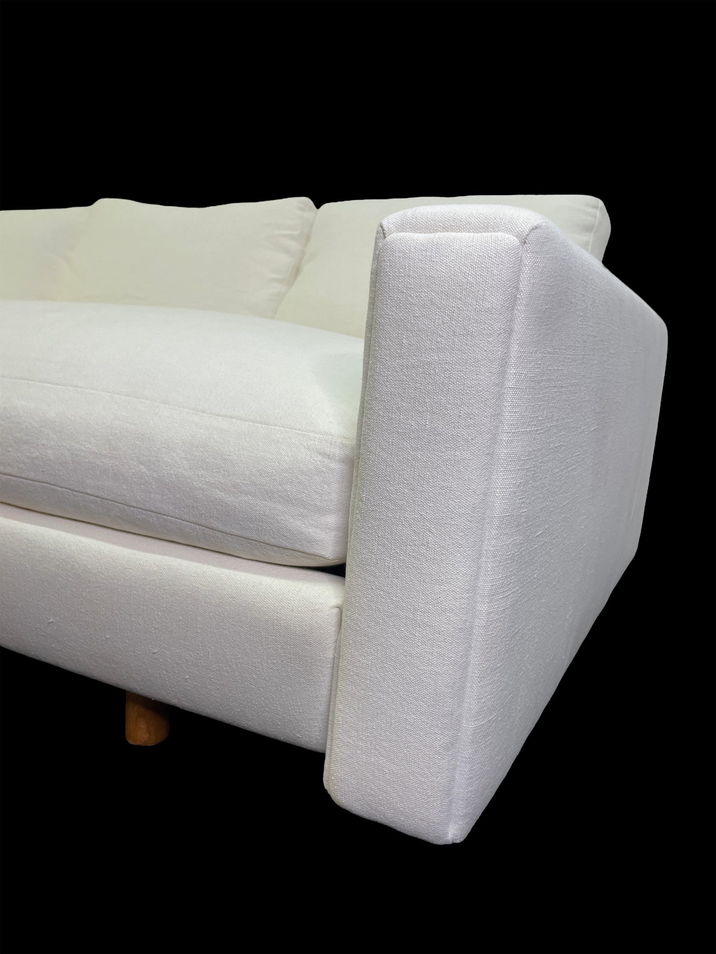 Close-up detail of sculptural angular arm on custom white upholstered contemporary daybed.