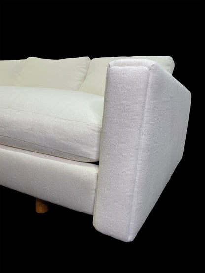 Close-up detail of sculptural angular arm on custom white upholstered contemporary daybed.