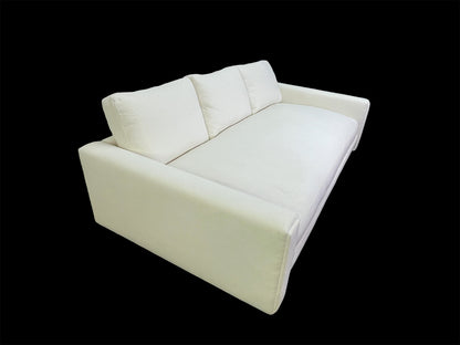 Three-quarter view of custom luxury white upholstered daybed with deep seat cushion and sculptural lines black background.