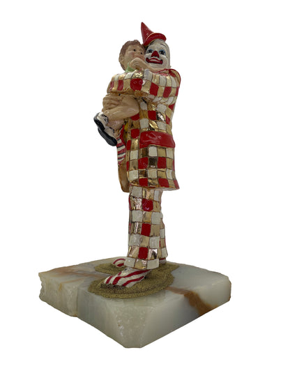 Signed Ron Lee 1985 sculpture of a child embracing a clown with 24K gold-plated accents on a natural onyx base, front left view.